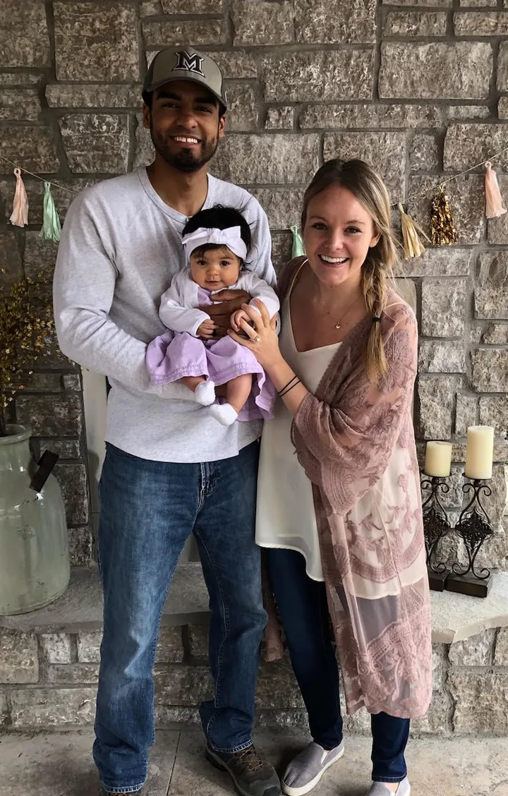 Parents holding their baby at home